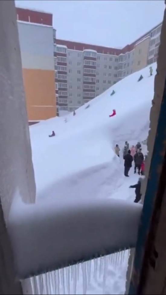 俄罗斯某地区暴雪堆积形成公寓楼雪坡此次暴雪强度创近30年降水量纪录